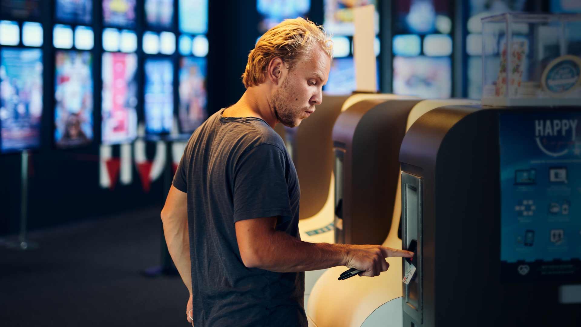 Man using a touchscreen kiosk for transactions.