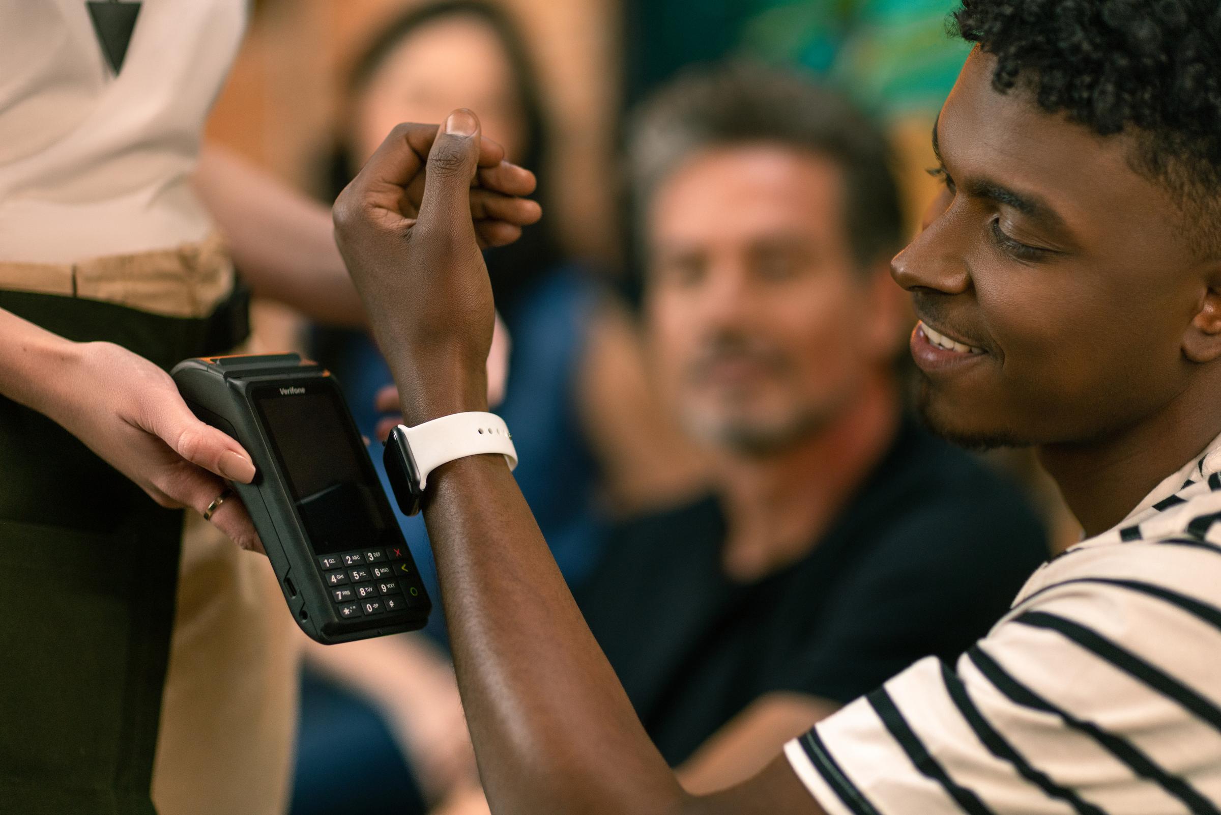 Pessoa pagando no terminal usando um dispositivo wearable