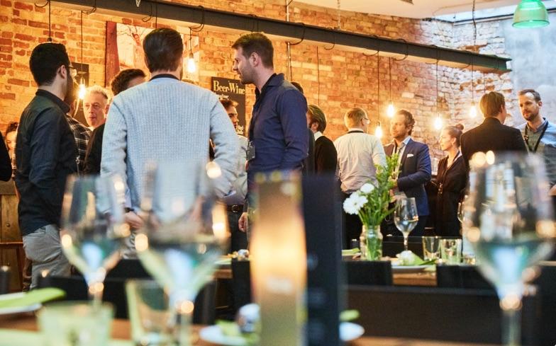 Grupo de pessoas em rede em um evento corporativo com fundo de tijolo