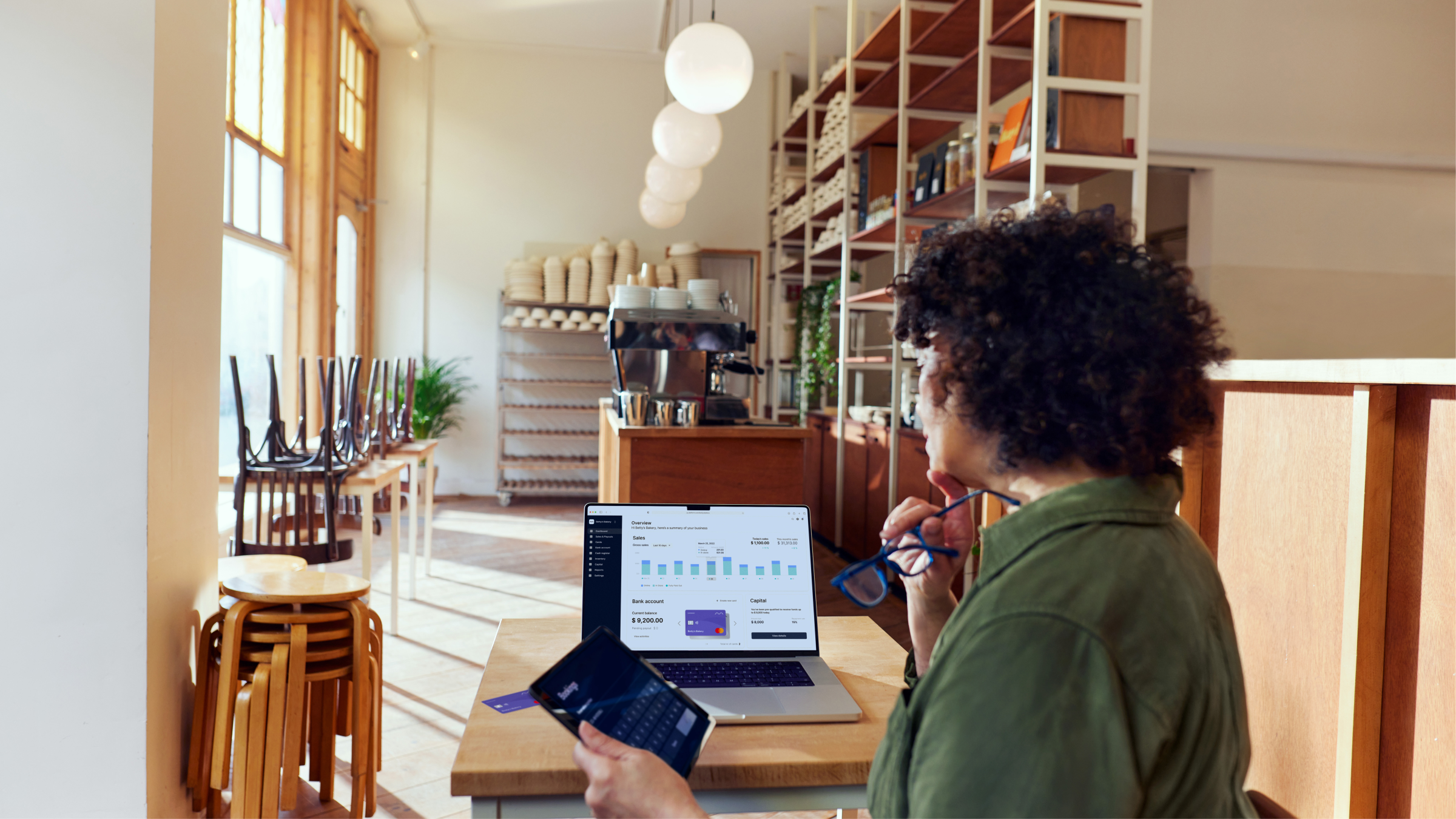 A woman in front of a data dashboard in a cafe.