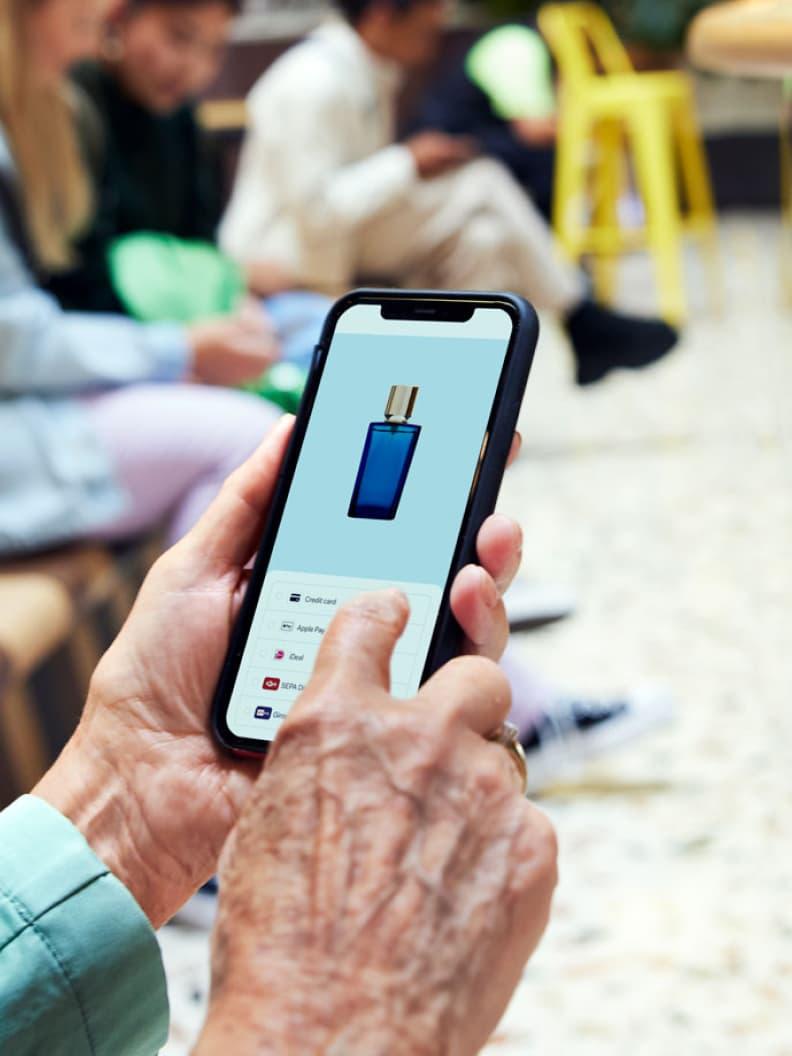 Close-up of a hand holding a smartphone showcasing a mobile payment app with multiple payment options.