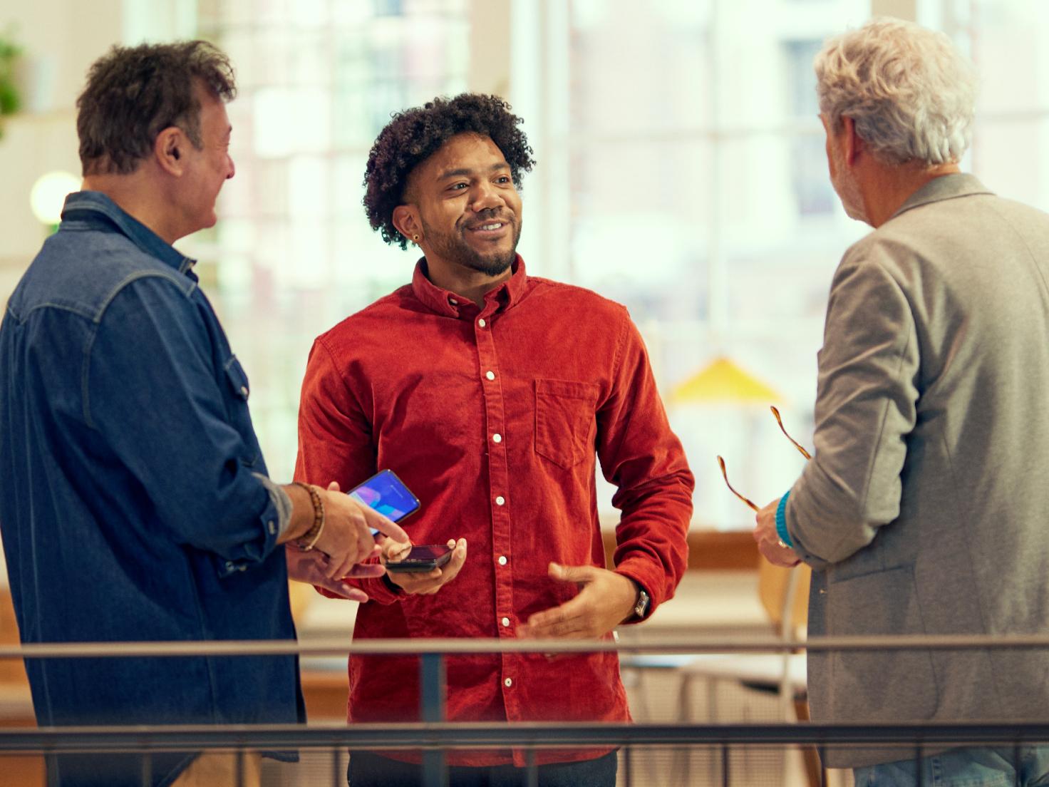 Three man discussing in a store over a mobile terminal payment