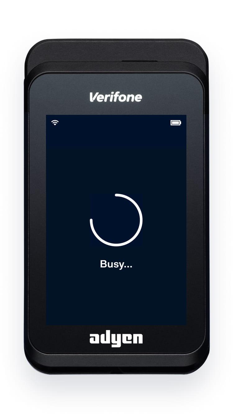 Verifone card terminal with Adyen branding on screen showing busy status.