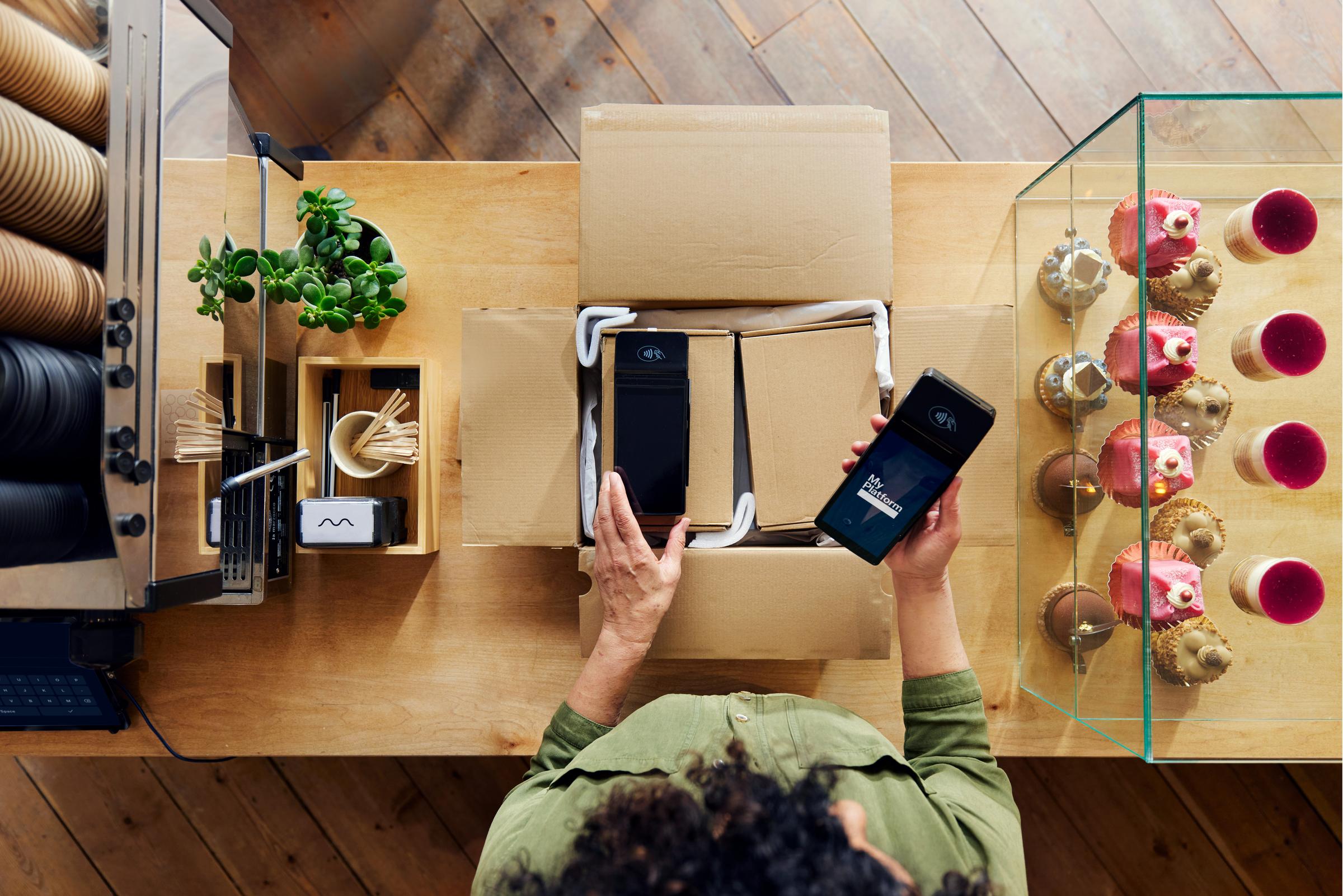 Dueño de una cafetería configurando y utilizando un terminal Adyen a través de una plataforma de software como servicio para alimentos y bebidas