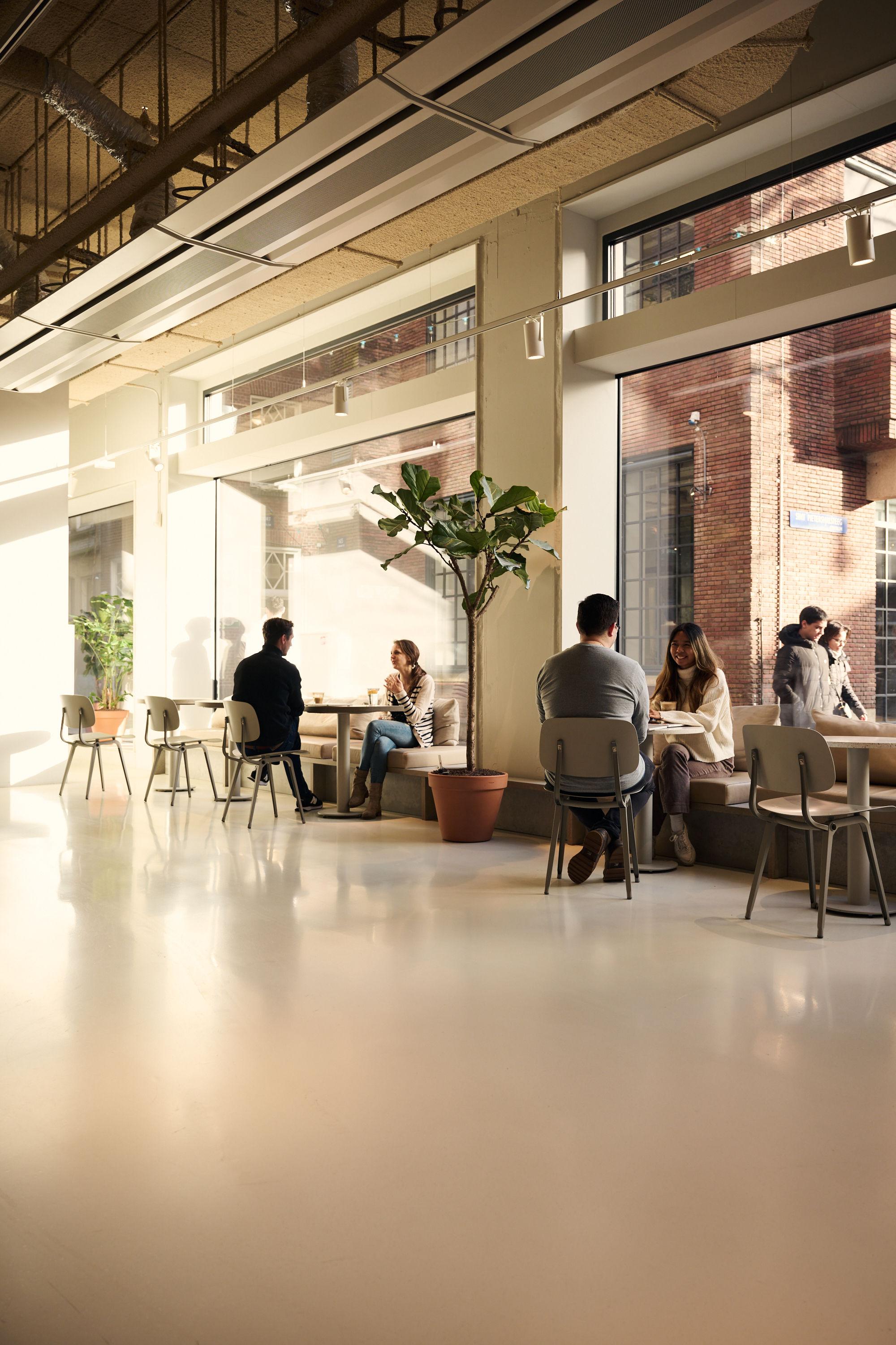 colleagues sitting in the lobby at the Rokin office near the window having coffee