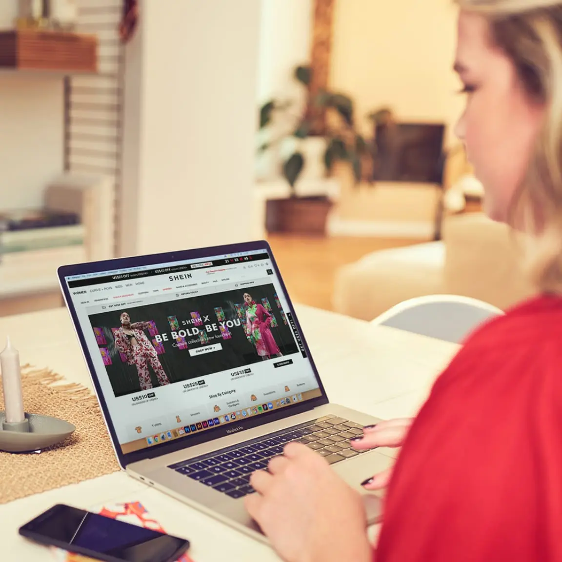 Woman shopping online on a fashion retail website using a laptop.