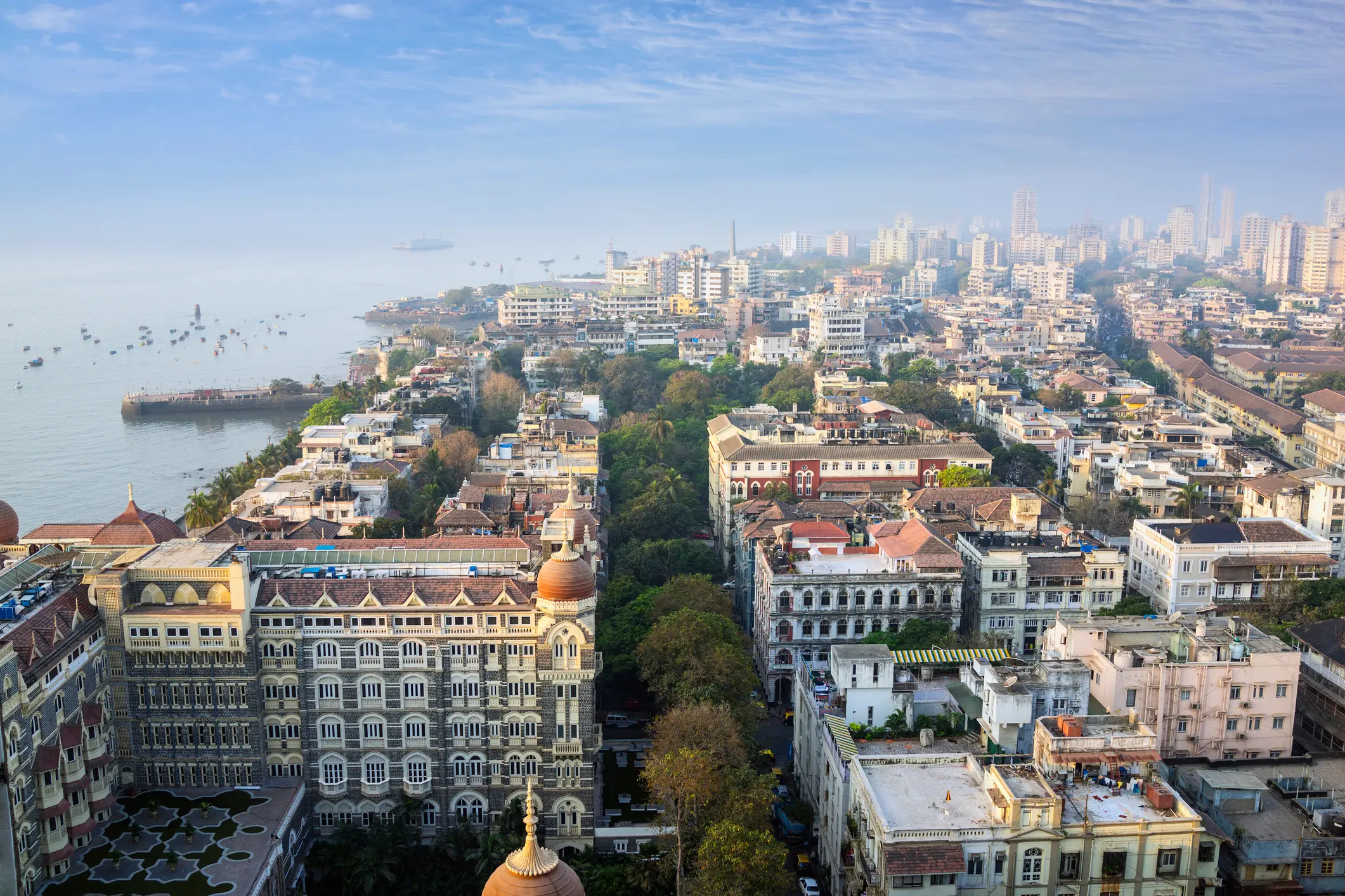 Aerial view of a cityscape near the coast with historic and modern buildings.
