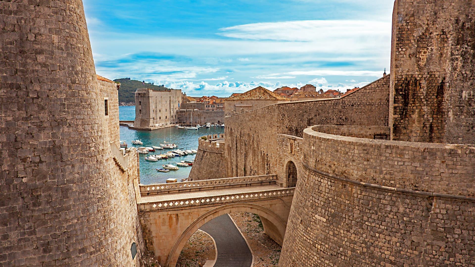 Ancient fortified walls with a stone bridge leading to the Sibenik city by the sea in Croatia.