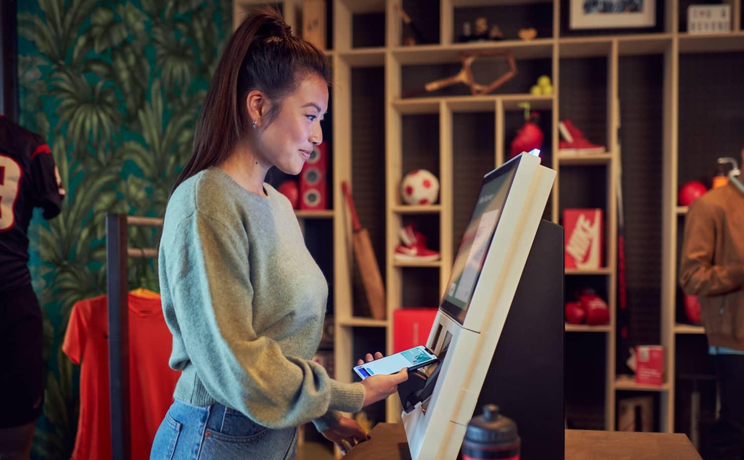 Woman using a contactless payment device at a store.