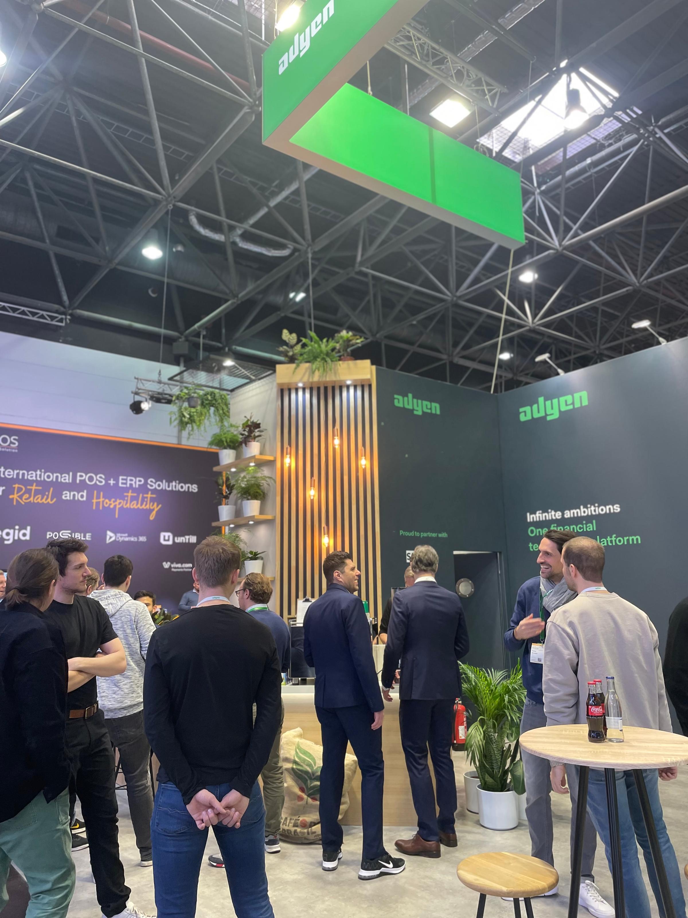 People at a tradeshow event at the Adyen Booth networking