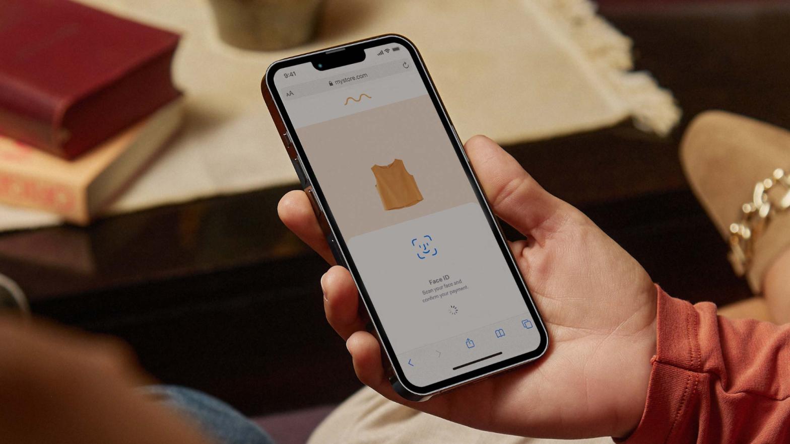 Person holding a smartphone showing an Adyen in-app payment page with Face ID confirmation.