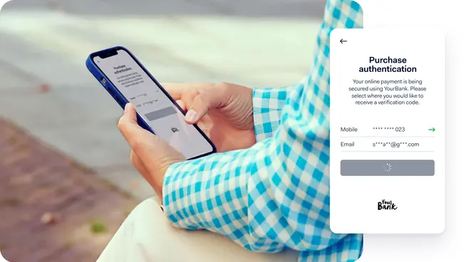 Person hält ein Smartphone mit einem vergrößerten Screenshot eines Kaufauthentifizierungsschritts in Ihrer Bank.