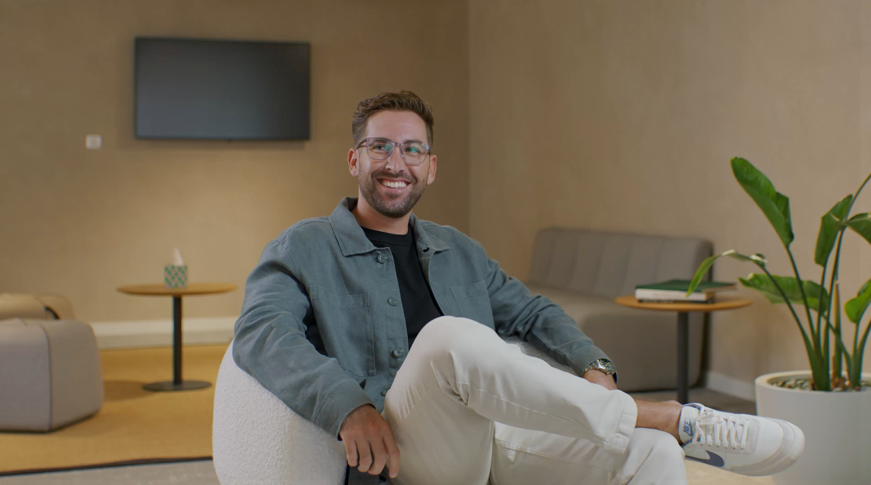 Adyen team member sitting confidently in the office environment.