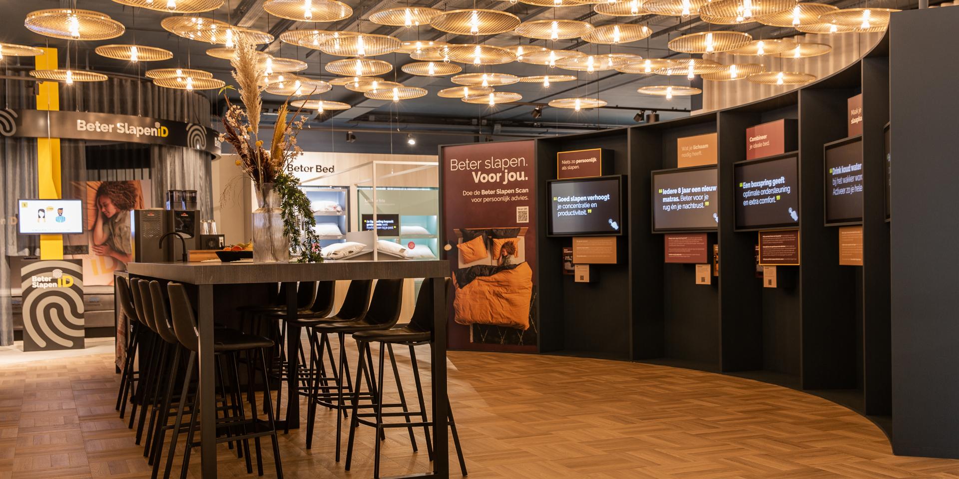 Moderne showroom met bar, verschillende informatieschermen en lichtarmaturen.