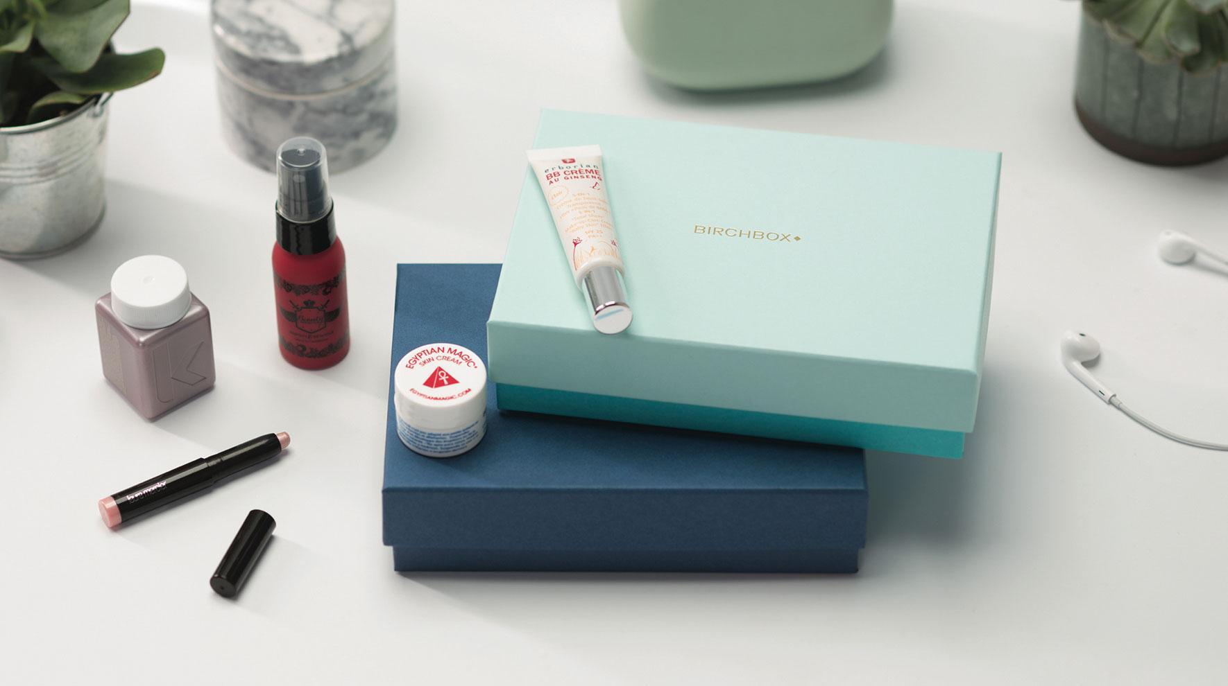 Assorted beauty products arranged with a Birchbox subscription box
