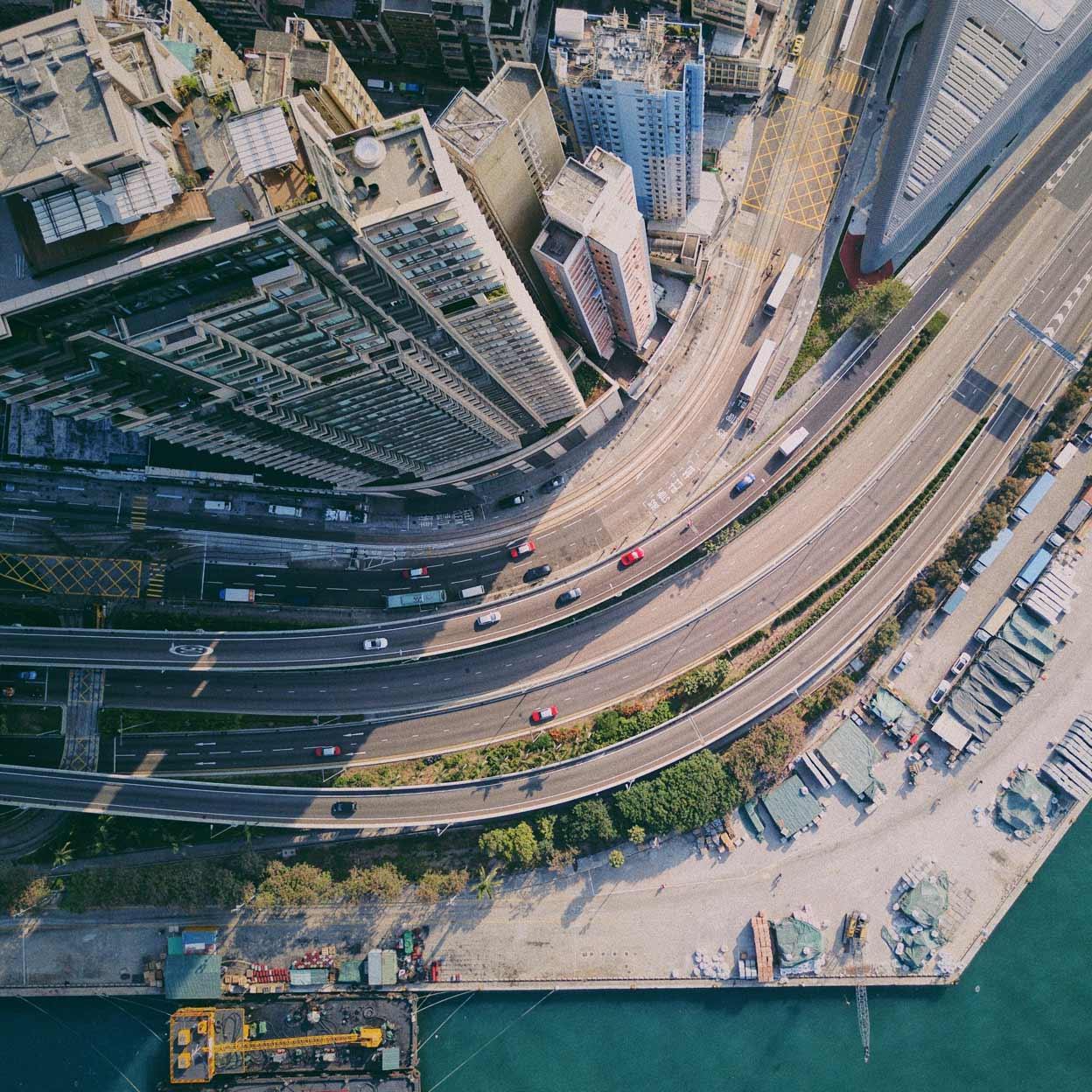 Vista aérea de una carretera curva con vehículos junto a edificios de la costa.