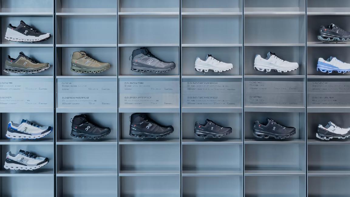 A collection of various shoes displayed on shelves with descriptive labels.