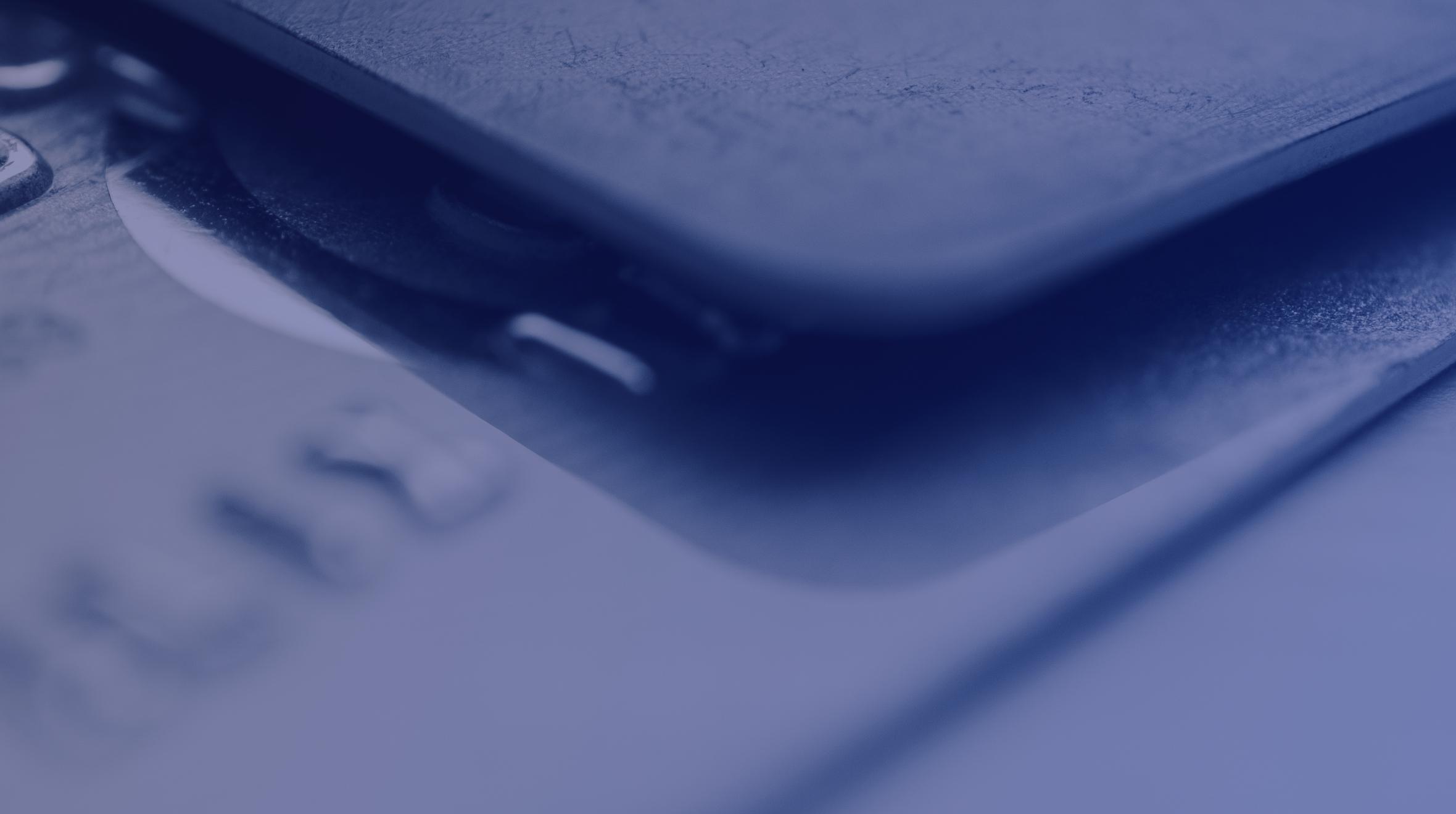 Nahaufnahme einer Kreditkarte, die teilweise von einem Smartphone mit unscharfem Effekt abgedeckt wird.