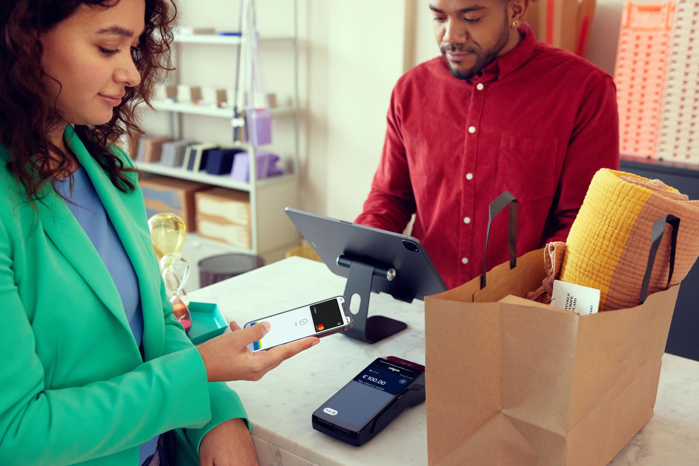 Kund betalar i en hem- och möbelaffär för tillbehör genom att knacka på en telefon på Adyens S1F2-terminal.