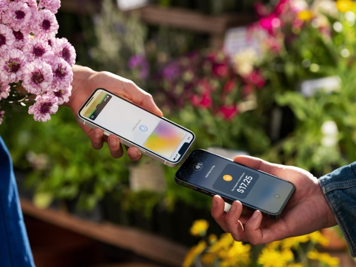 Two hands exchanging payment via smartphone with a visible transaction amount.