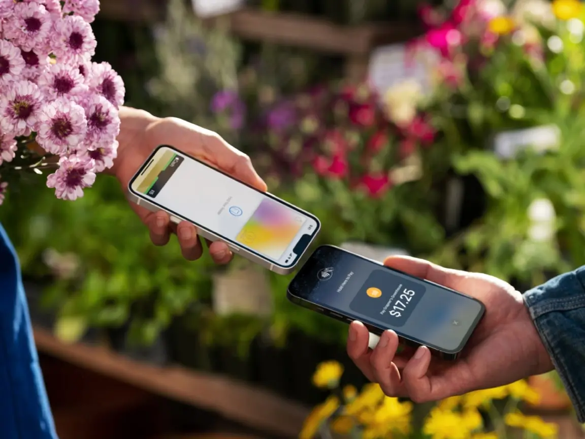 Two hands exchanging payment via smartphone with a visible transaction amount.