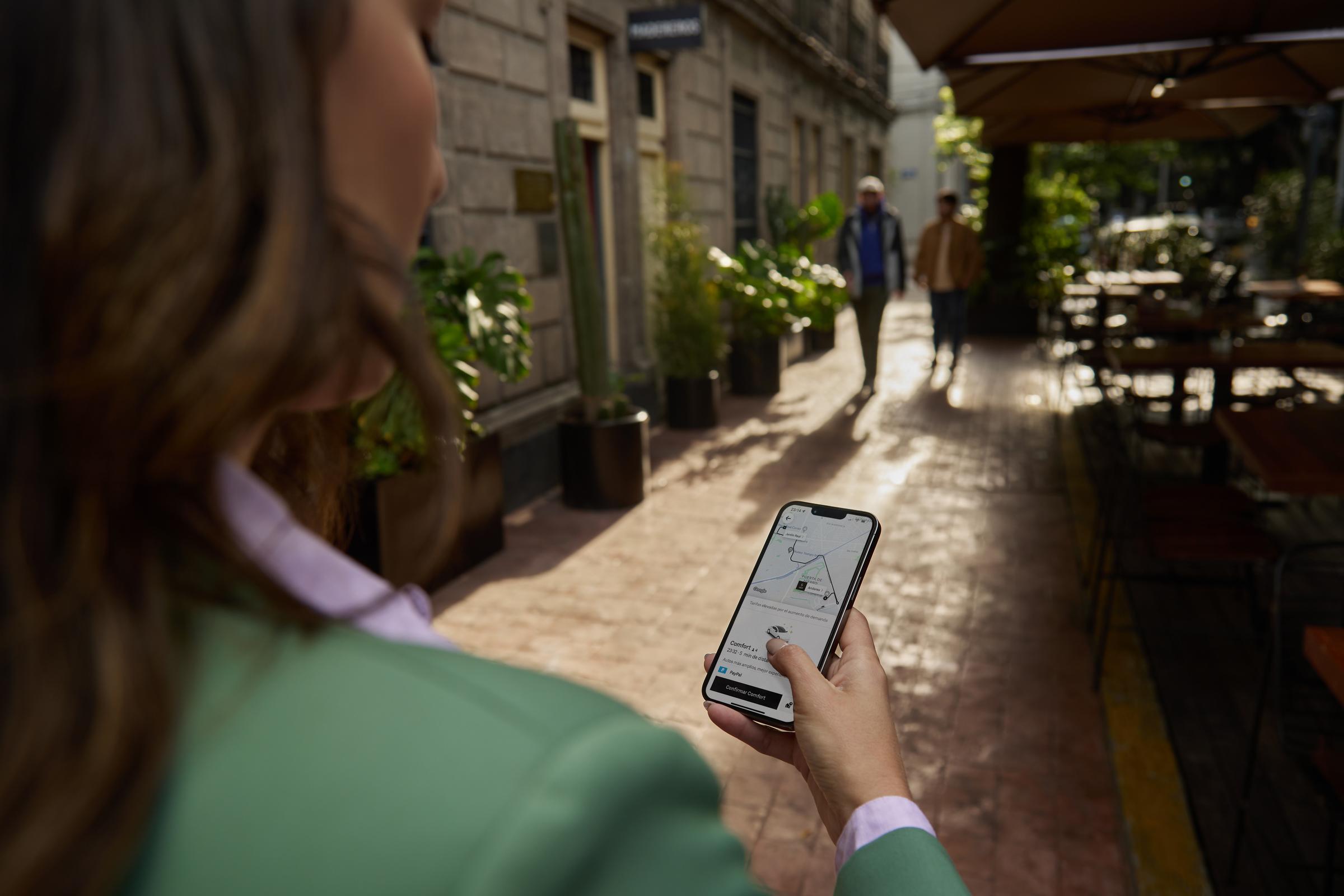 Woman on the street ordering an uber/rideshare/taxi on her phone