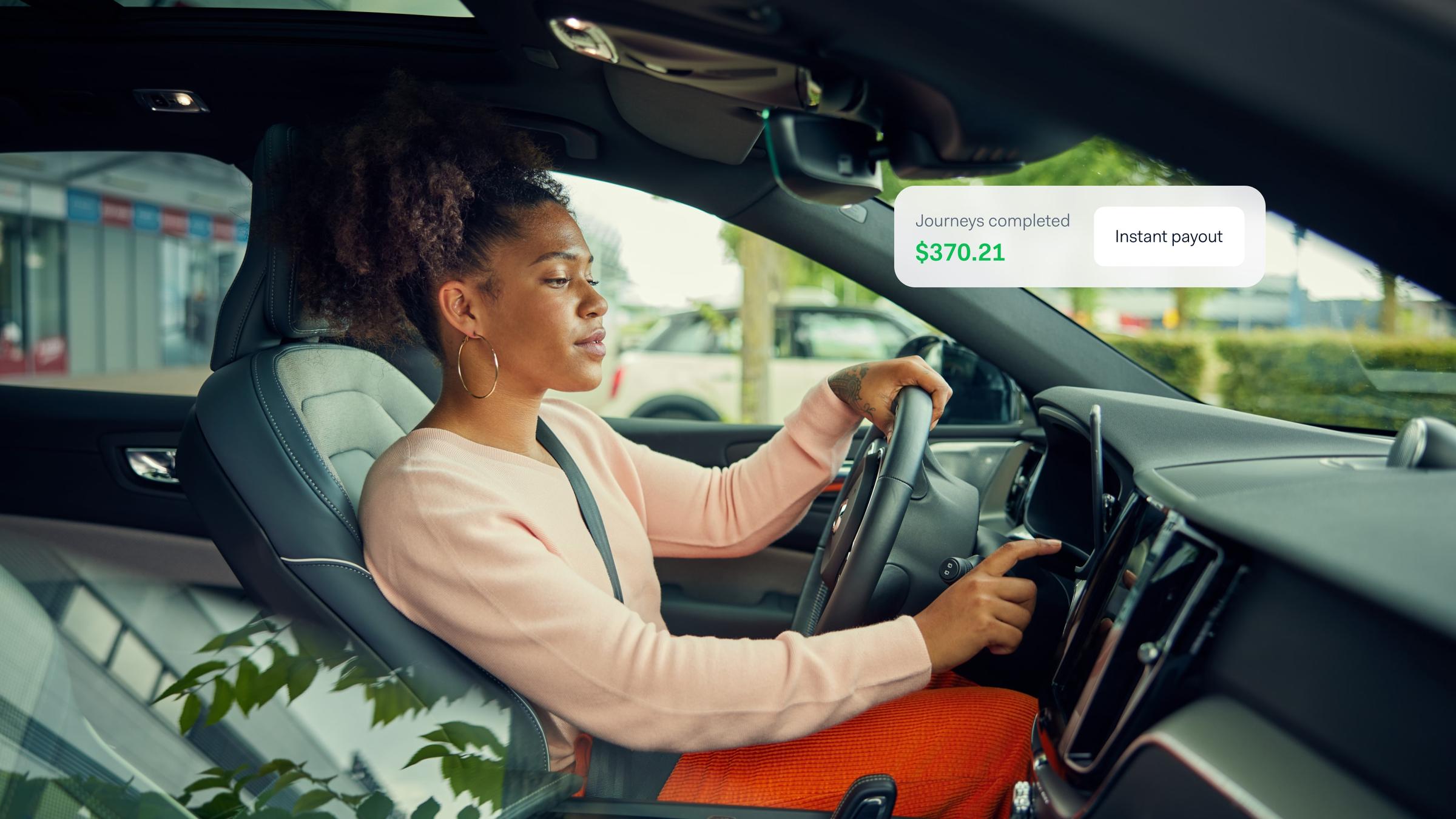 Driver in car checking earnings and instant payout option on Adyen payment system.