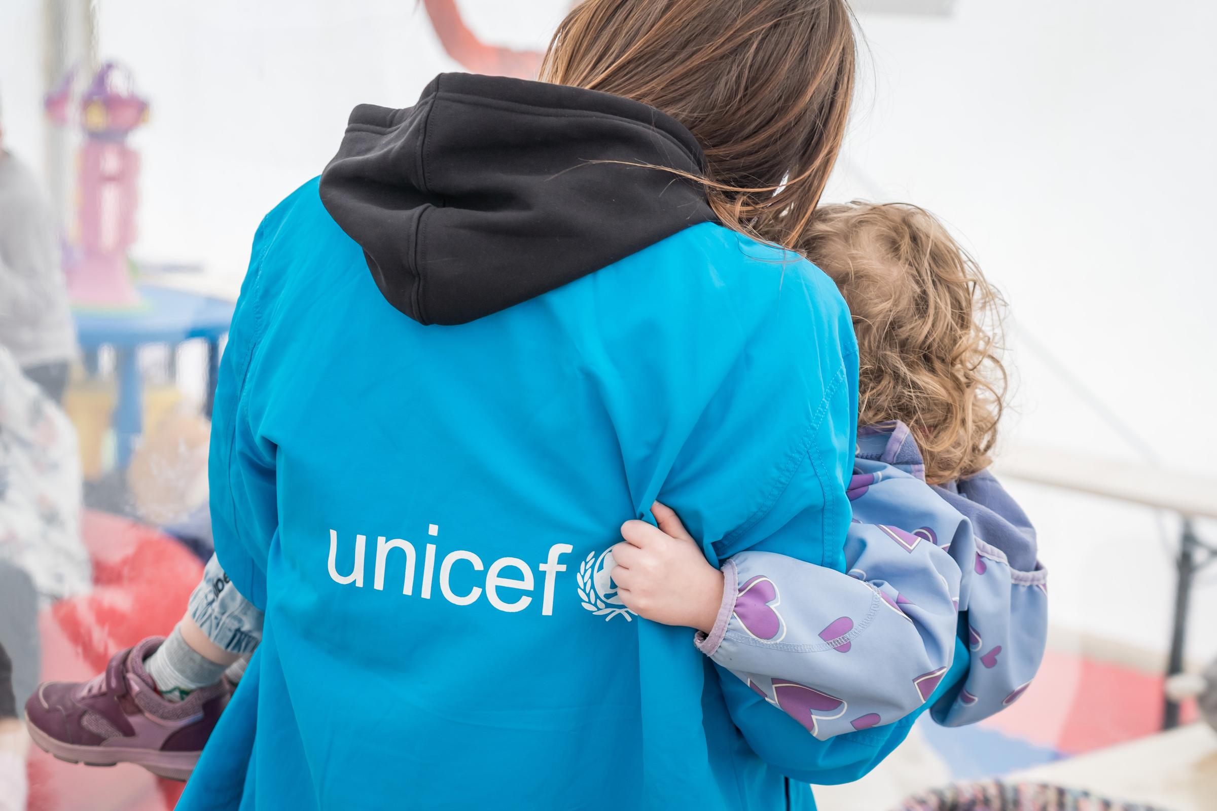 UNICEF volunteer holding a child