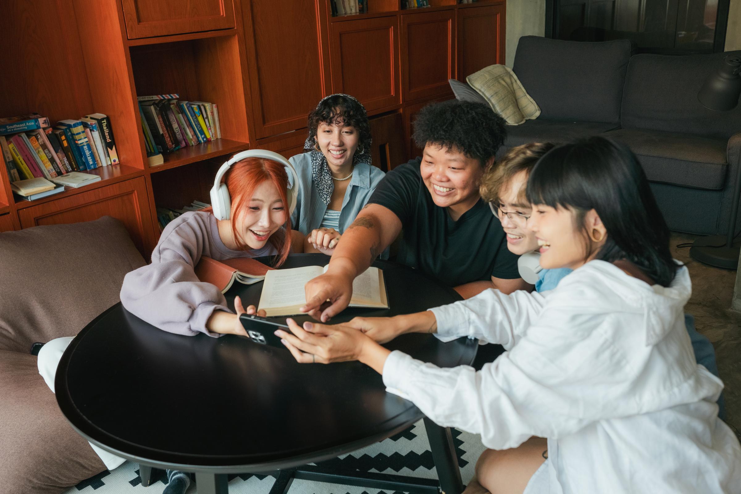 Adyen team members collaborating around a table with a payment device in a library setting