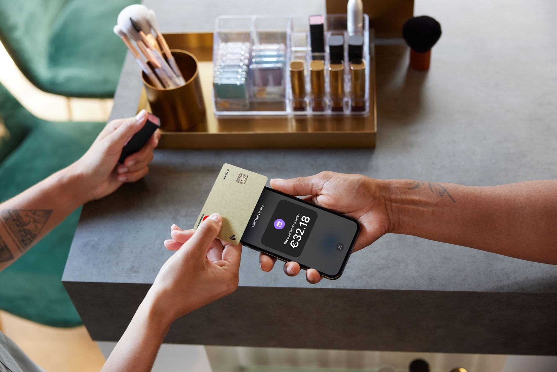 Persoon die een betaling doet met een contactloos bankkaart en een smartphone met een betaalapp