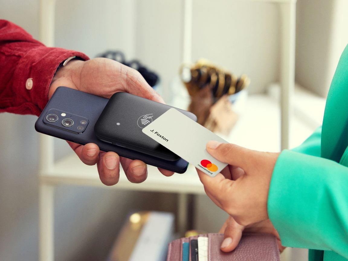 Person using a smartphone to accept a contactless payment from a credit card.