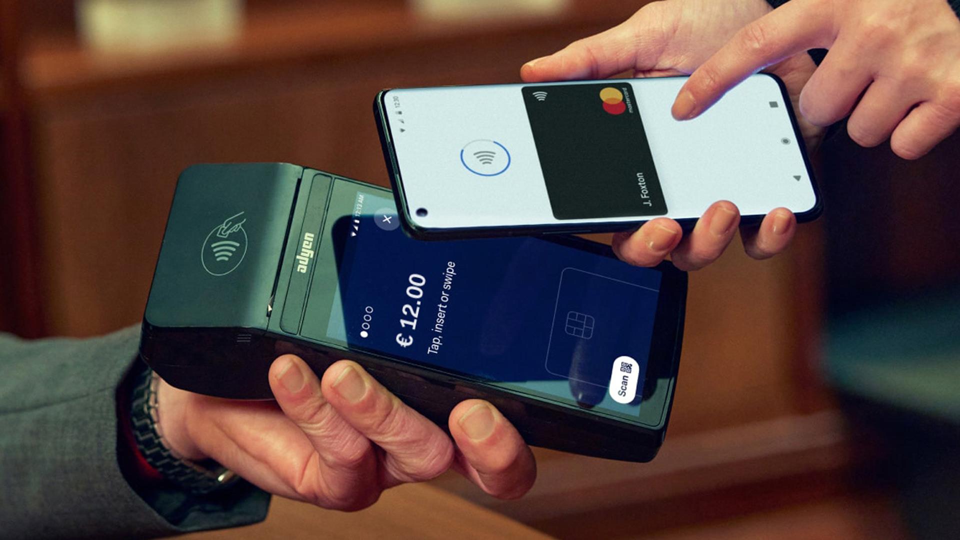 Person macht eine kontaktlose Zahlung mit einem Smartphone über ein Zahlungsterminal