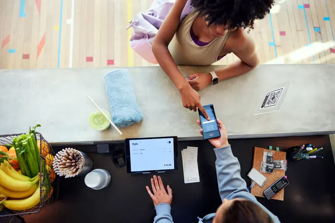 A woman at a gym confirming her loyalty points on Adyen's S1E terminal.