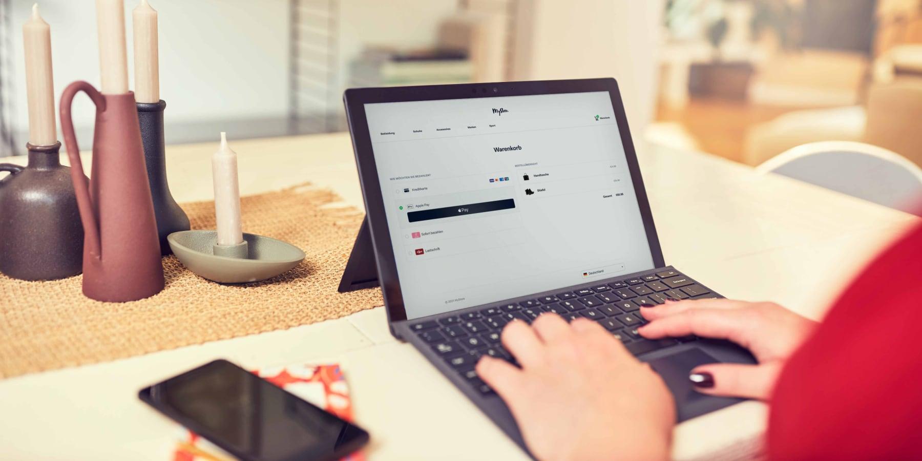 Person nutzt einen Laptop mit Adyen-Checkout-Seite mit Zahlungsoptionen.