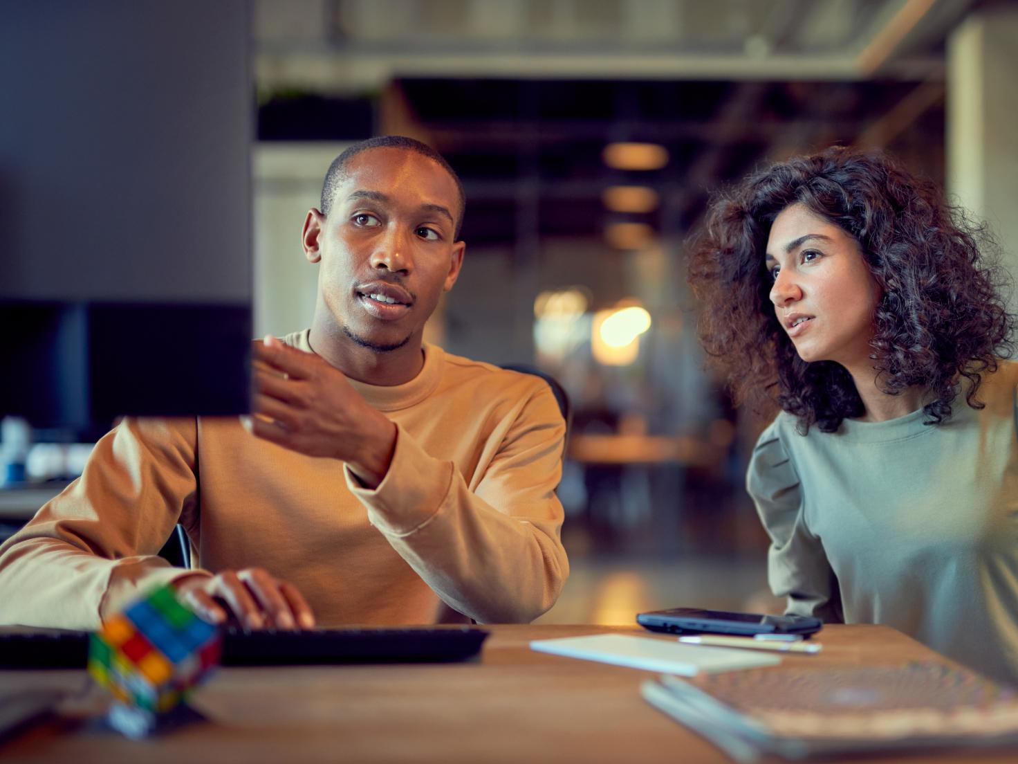 Two colleagues looking together at a screen