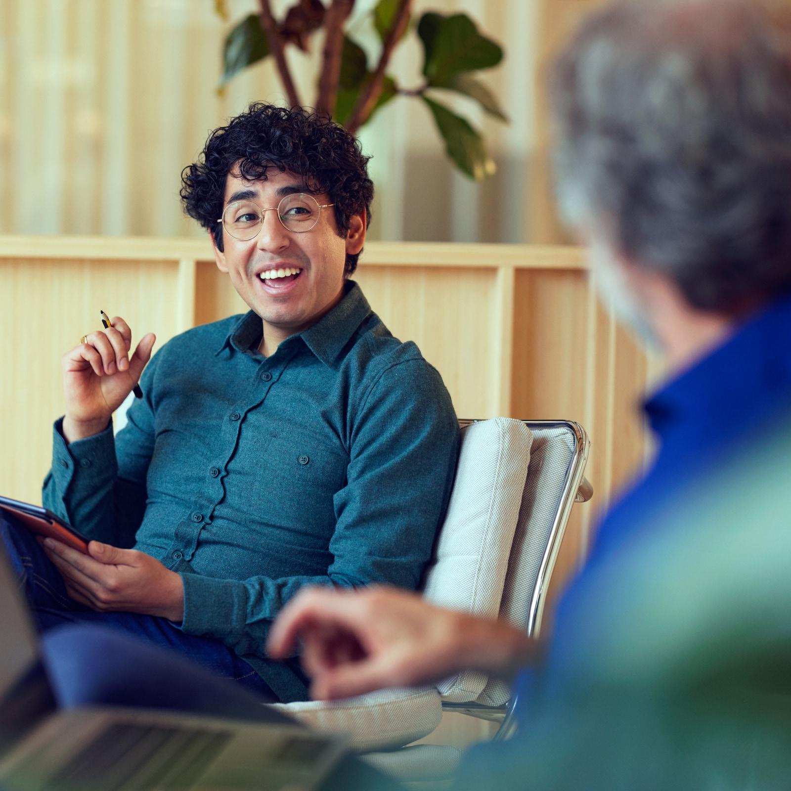 Smiling person with glasses in a conversation at an office setting