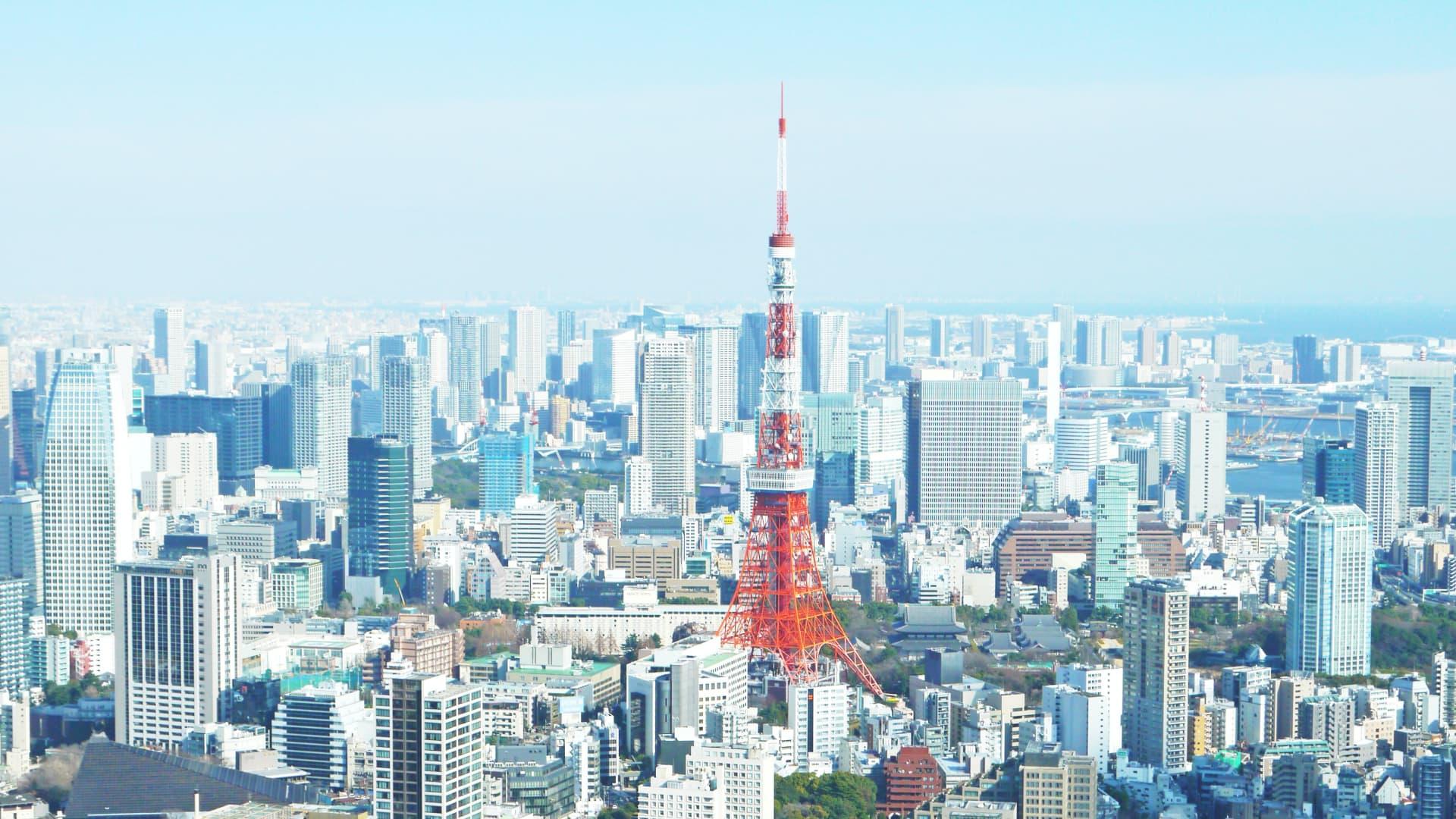 Aerial view of Tokyo with Tokyo Tower at the center surrounded by buildings.