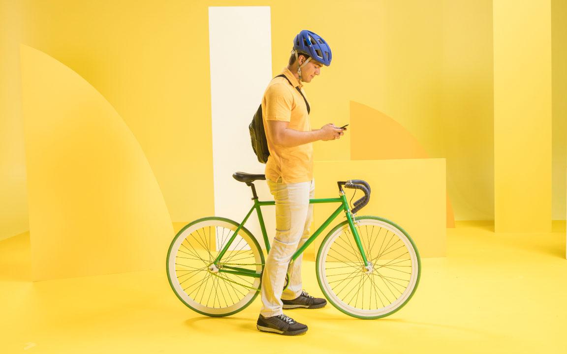 Man standing with bike looking at phone