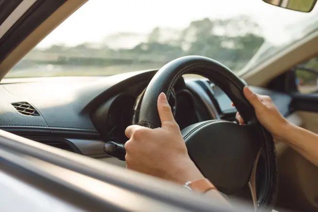 Focus shot of hands on a steering wheel.