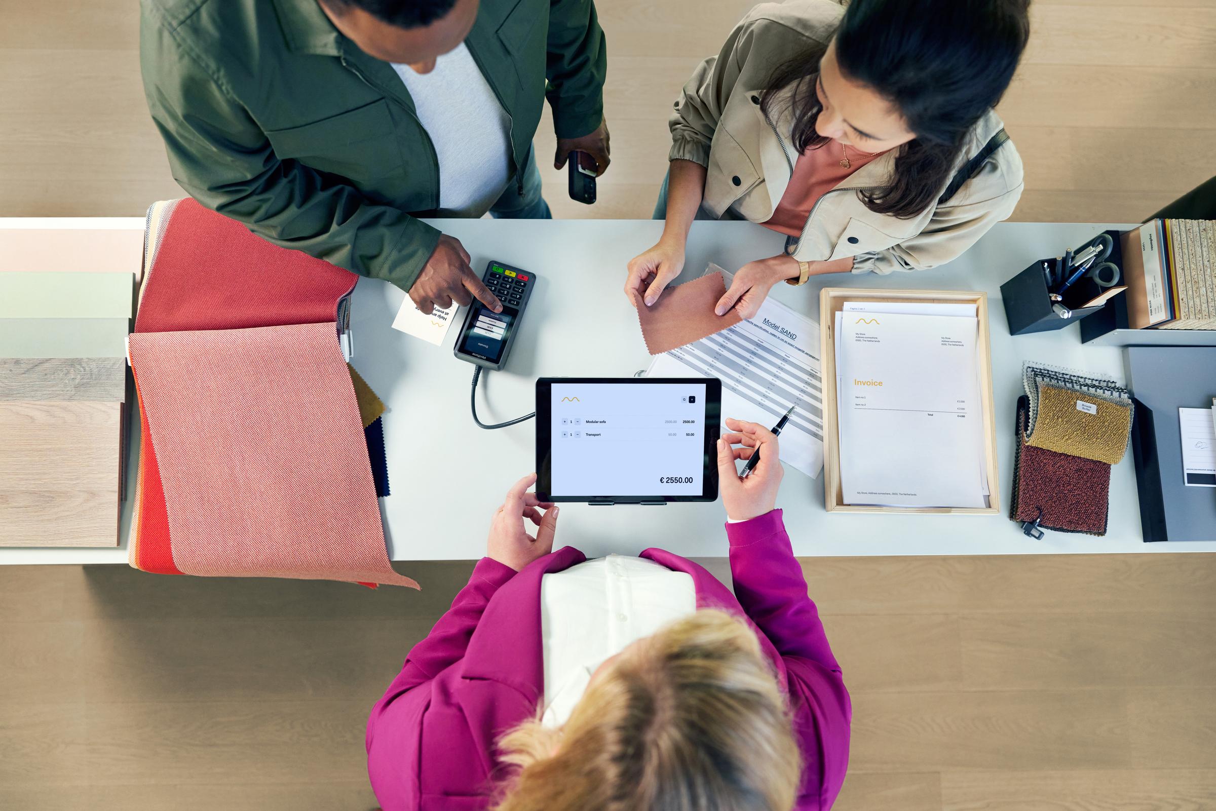 Un couple dans un magasin de meubles payant et faisant un don sur le terminal P400Plus d'Adyen.