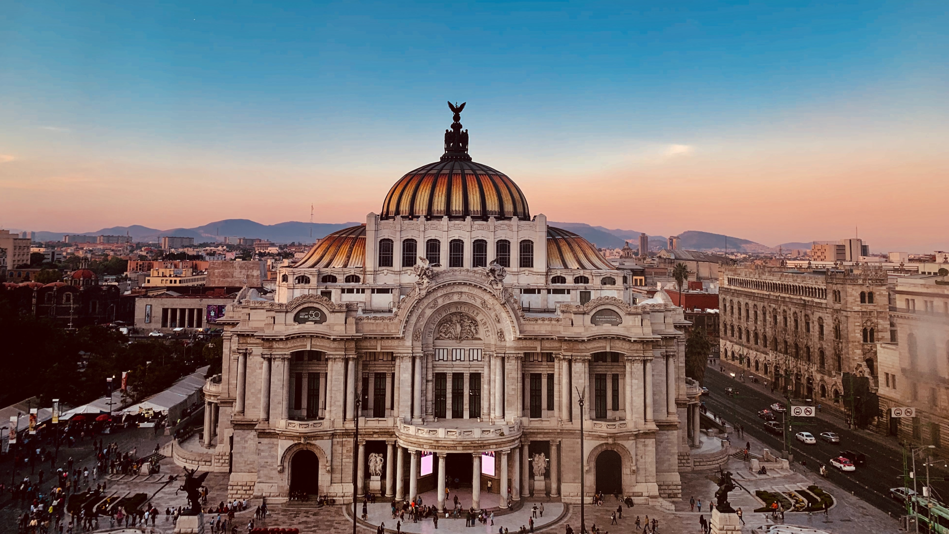 Twilight view of Palacio de Bellas Artes in Mexico City with busy streets.