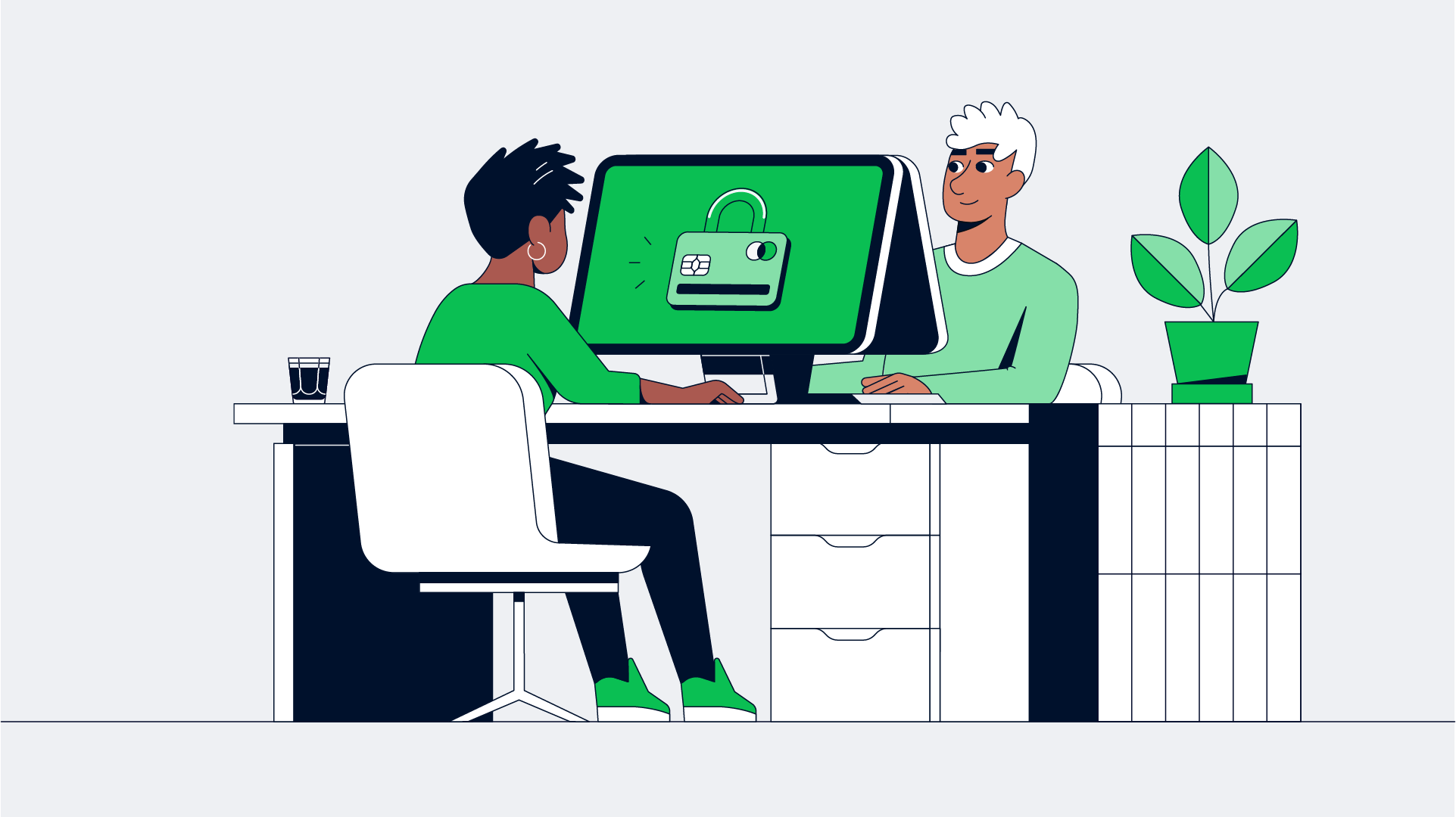 Two individuals discussing security features on a computer screen displaying a lock icon and a credit card