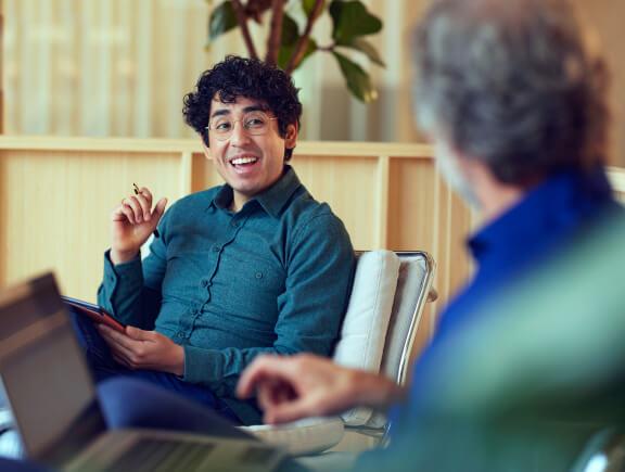 Due individui impegnati in una discussione con uno che tiene un tablet.