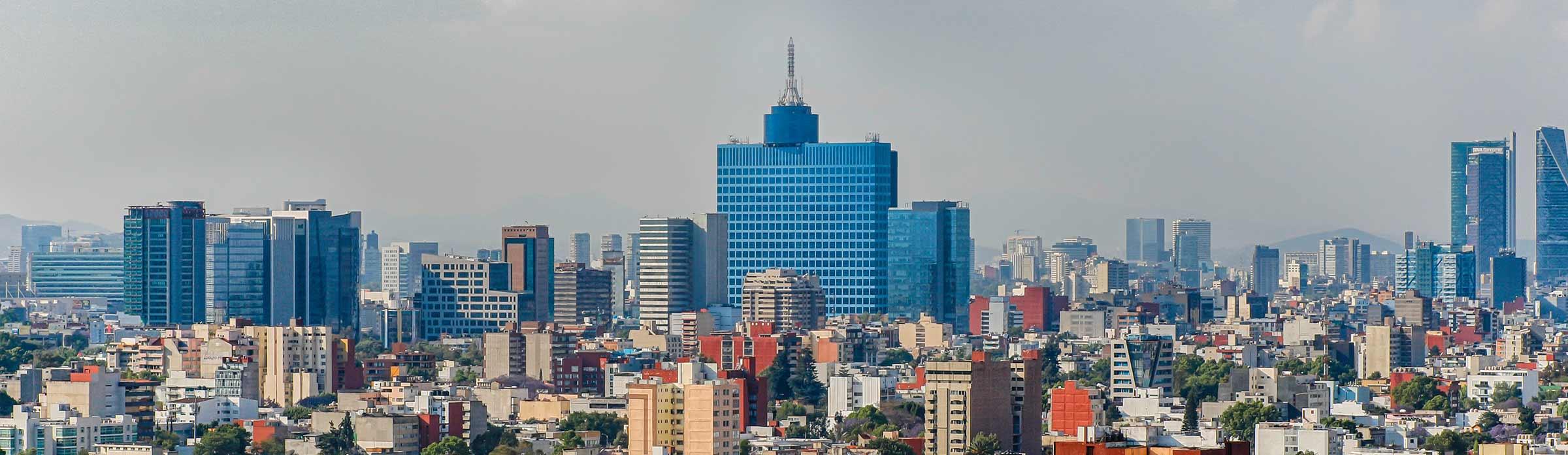 Paisaje urbano panorámico con una variedad de edificios modernos bajo cielos claros.