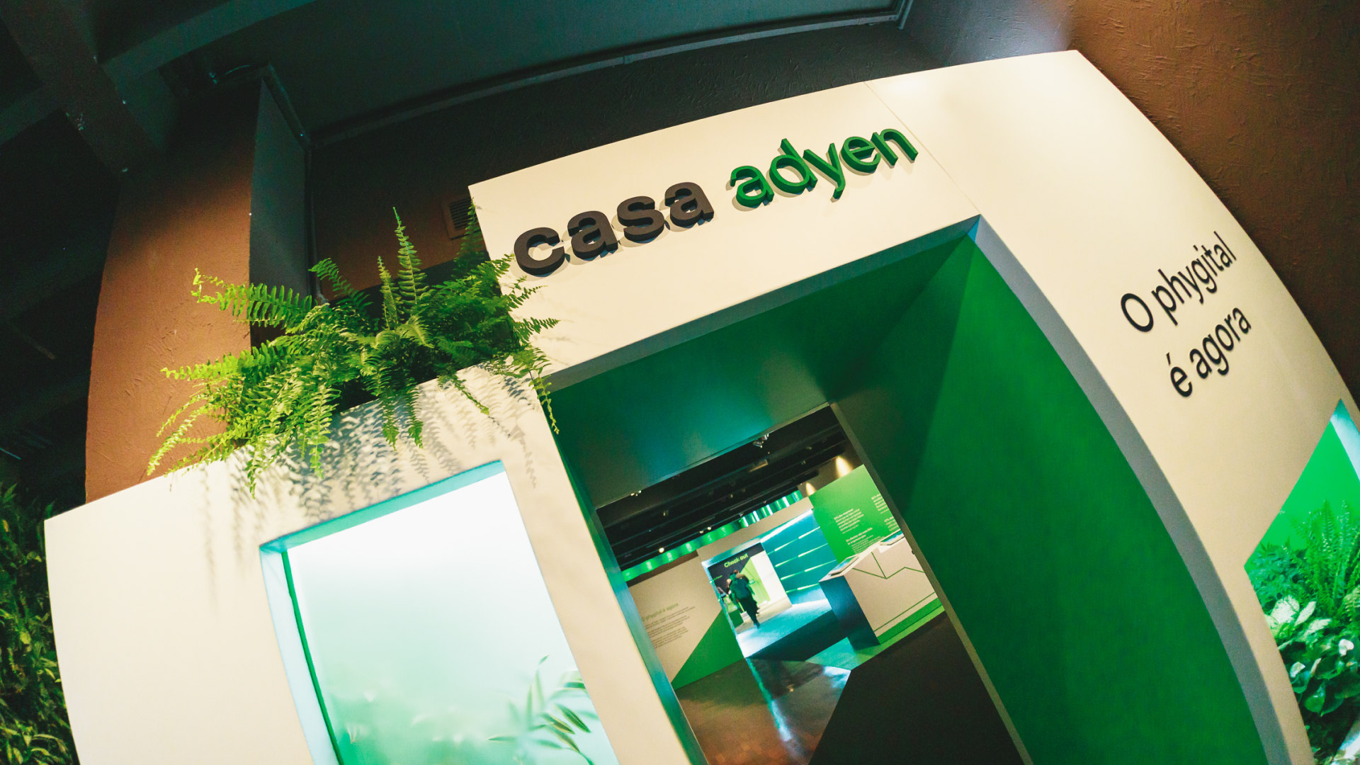 Casa Adyen stand com branding verde e texto 'O phygital é agora'