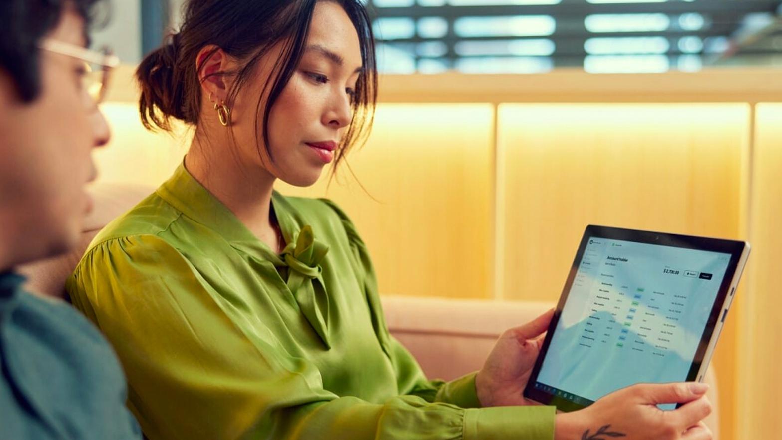 Deux professionnels examinant les fonctionnalités du produit Adyen sur une tablette numérique.