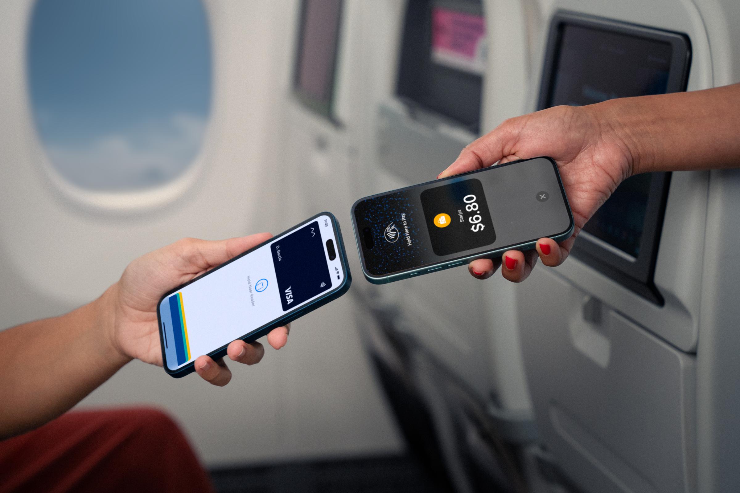 Travelers using a mobile device to complete a contactless payment via an Adyen terminal onboard.