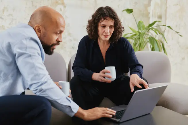 Colleagues of a tech Saas company in meeting discussing over a laptop