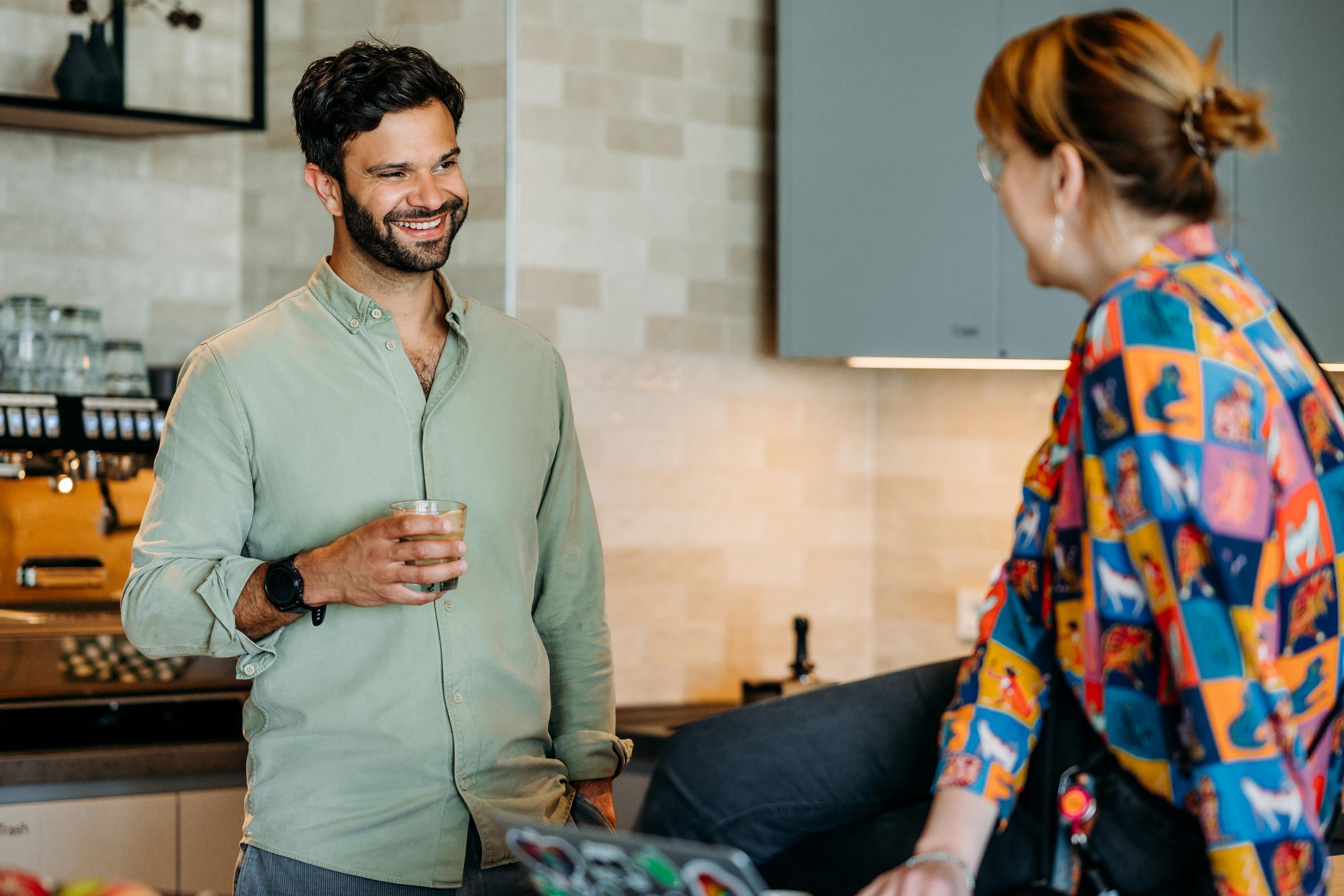 Two people in the coffee area laughing 