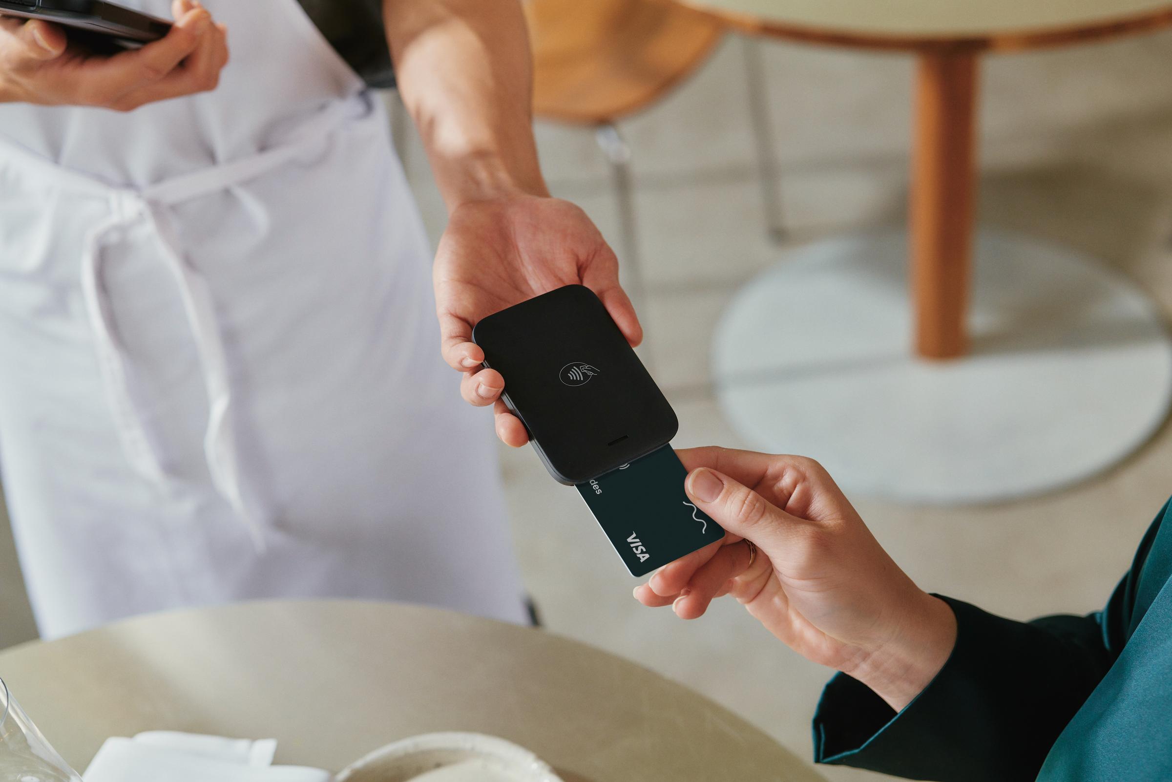 A person in a restaurant inserting a VISA card into Adyen's NYC1 terminal.